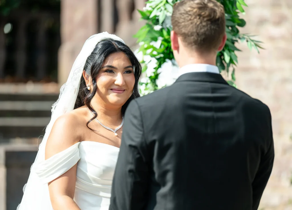 Aryana smiling at Ben during their personalized wedding ceremony at Tyler Gardens in Newtown, Pennsylvania