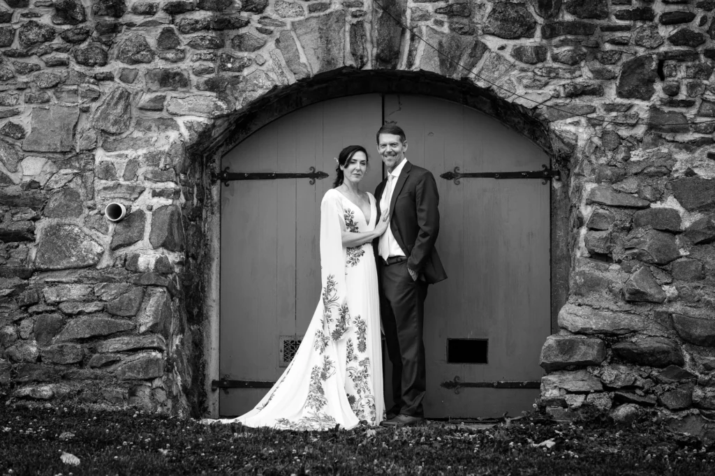 Ellie and Doug pose together beneath a stone arch at Vixen Hill Farm.