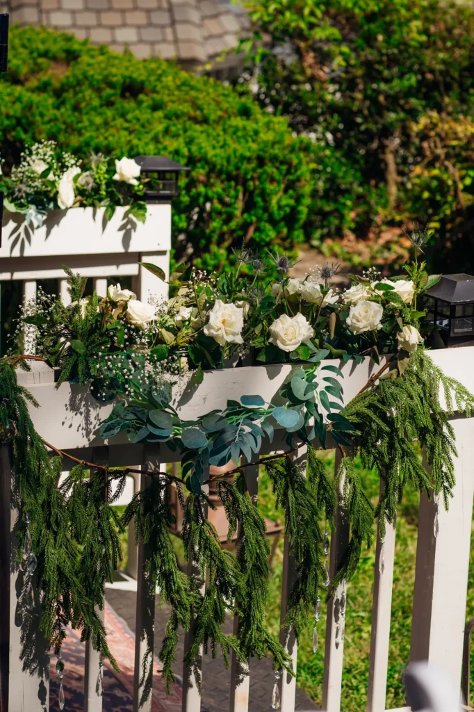White flowers and greenery surrounding the woodland ceremony setting at Vixen Hill Farm.