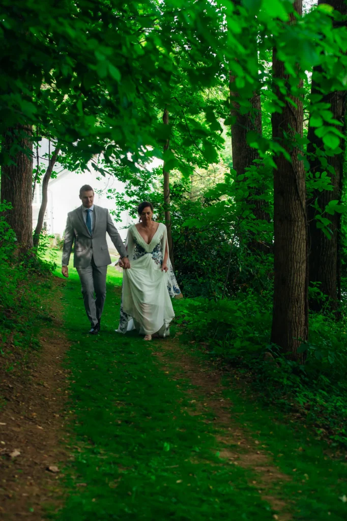 Ellie walking beneath the trees at Vixen Hill Farm on her wedding day.
