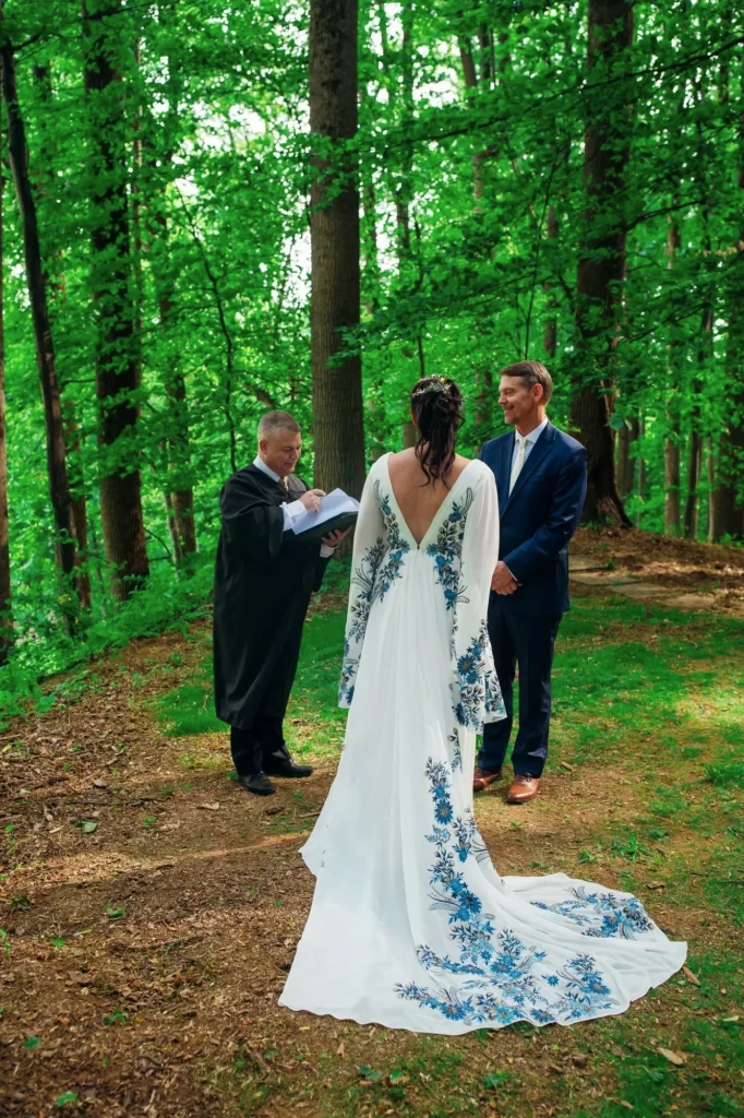 Ellie and Doug standing with their officiant during their woodland wedding ceremony at Vixen Hill Farm